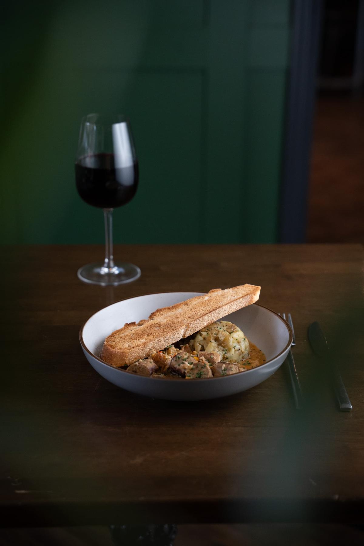 Casserole with toast and a glass of wine at Toast